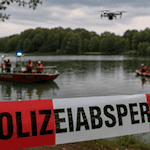 Symbolbild: Einsatzkräfte suchen mit Booten und einer Drohne auf einem See. Das Bild wurde mithilfe künstlicher Intelligenz generiert und zeigt nicht den tatsächlichen Einsatz am Werratalsee.