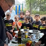 Die Schülerinnen und Schüler der teilnehmenden Grundschulklassen bereiteten gemeinsam verschiedene Gerichte zu. Dabei unterstützte sie Grillmeister Ralf Richter von den Grillninjas.Foto SPK