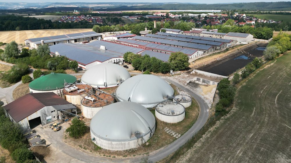 Blick auf eine Biogasanlage einer Agragenossenschaft. Dahinter sind Gebäude mit Solarpanelen zu sehen. / Foto: Bodo Schackow/dpa/Archivbild