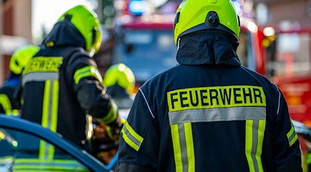 Feuerwehrleute stehen um ein Auto, das einen Unfall gehabt hat. / Foto: David Inderlied/dpa/Symbolbild