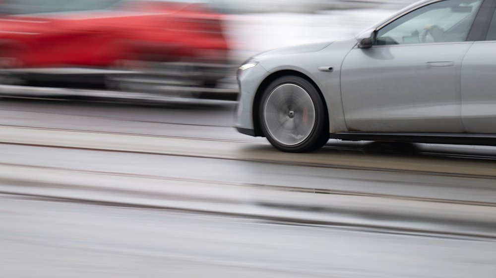 Ein graues Autos fährt auf einer Straße in einer Innenstadt entlang. / Foto: Robert Michael/dpa/Symbolbild