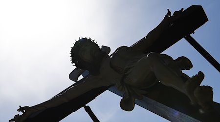 Gläubige tragen bei der Palmsonntagsprozession im Eichsfeld eine überlebensgroße Darstellung "Kreuzigung", die das Leiden und Sterben Jesu Christi symbolisiert. / Foto: Swen Pförtner/dpa-Zentralbild/dpa