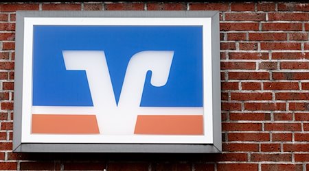 Das Logo der Volks- und Raiffeisenbanken hängt über einer Geschäftsstelle. / Foto: Markus Scholz/dpa