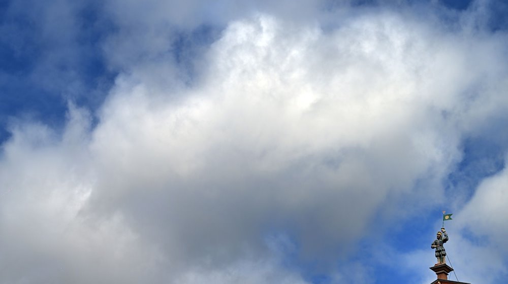 Wolken ziehen über die Statue eines Landsknechts auf dem Haus zum breiten Herd am Fischmarkt. / Foto: Martin Schutt/dpa