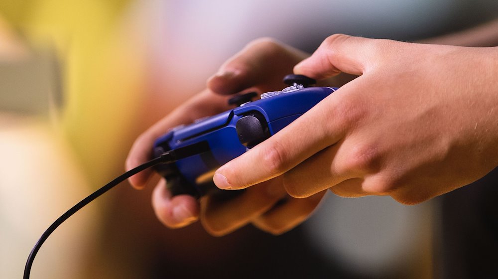 Ein Mann spielt ein Videospiel mit einem Controller. / Foto: Marius Becker/dpa