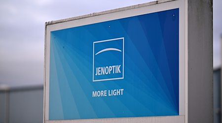 Das Logo des Technologie-Konzerns Jenoptik auf dem Schild vor dem Technologiezentrum. Hauptsitz des Konzerns ist Jena. / Foto: Martin Schutt/dpa