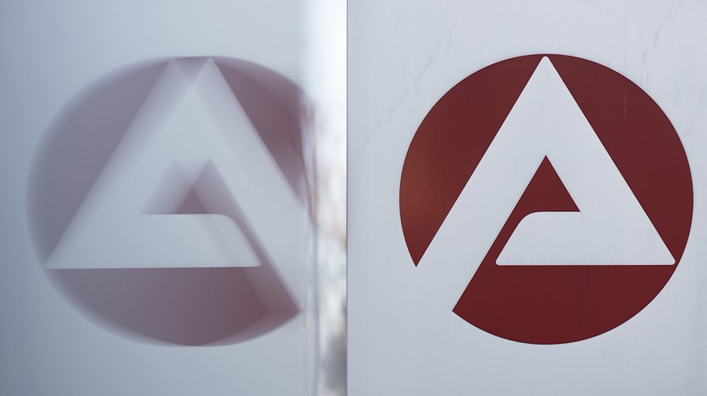 Das Logo der Bundesagentur für Arbeit spiegelt sich in einer Scheibe. / Foto: Sebastian Kahnert/dpa