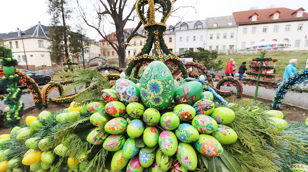 Mit bunten Ostereiern geschmückt ist die Osterkrone rund um den Osterbrunnen. / Foto: Bodo Schackow/dpa