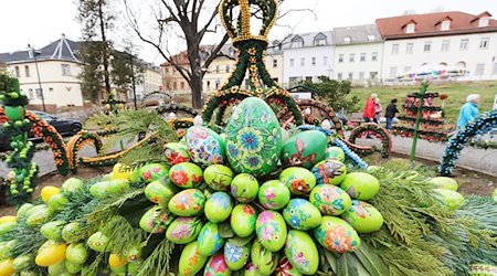 Mit bunten Ostereiern geschmückt ist die Osterkrone rund um den Osterbrunnen. / Foto: Bodo Schackow/dpa