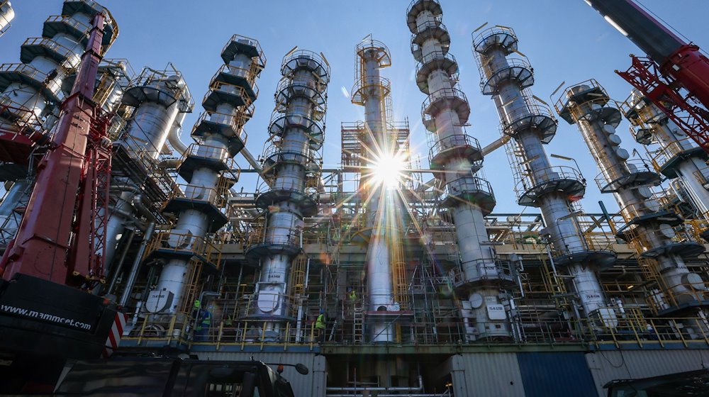 Die Sonne scheint hinter einer Kolonne zur Phenolherstellung bei der Domo Chemicals GmbH. / Foto: Jan Woitas/dpa