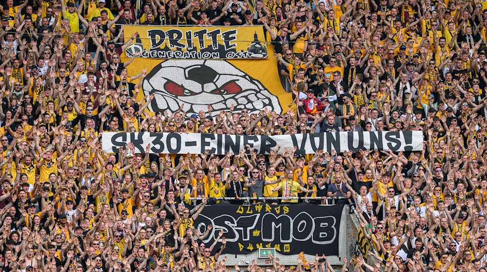 Dynamos Fans im K-Block zeigen ein Banner für Stefan Kutschke mit der Aufschrift „SK 30 - einer von uns!“. / Foto: Robert Michael/dpa