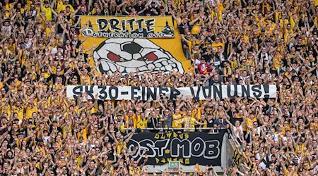 Dynamos Fans im K-Block zeigen ein Banner für Stefan Kutschke mit der Aufschrift „SK 30 - einer von uns!“. / Foto: Robert Michael/dpa
