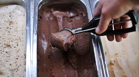 Ein Mann formt in einer Eisdiele eine Kugel Chili-Schokoladeneis. / Foto: Ole Spata/dpa