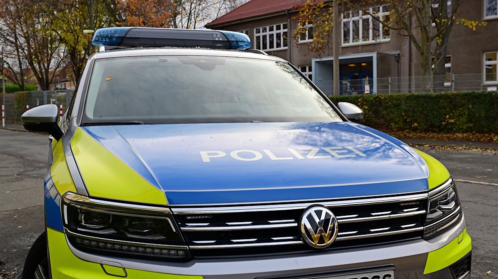 Ein Polizeifahrzeug steht vor der Erfurter Grundschule am Schwemmbach. / Foto: Martin Schutt/dpa