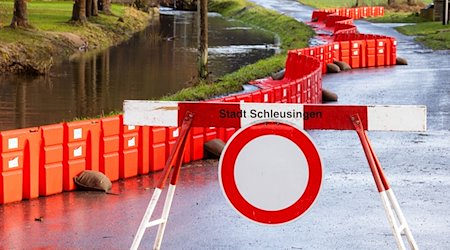 Eine Absperrung steht neben einem mobilen Damms, der Anwohner des Ortsteils Rappelsdorf vor dem Fluß Schleuse schützen soll. / Foto: Michael Reichel/dpa