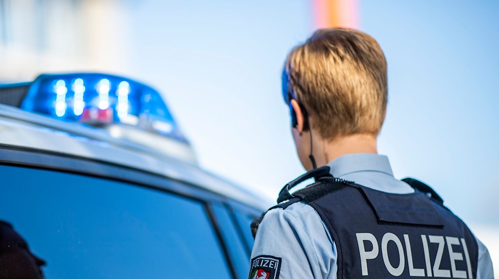 Eine Polizistin steht neben einem Streifenwagen. / Foto: David Inderlied/dpa/Illustration