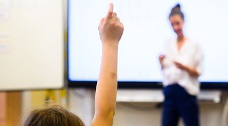 Ein Schüler meldet sich per Handzeichen in einem Klassenraum. / Foto: Julian Stratenschulte/dpa