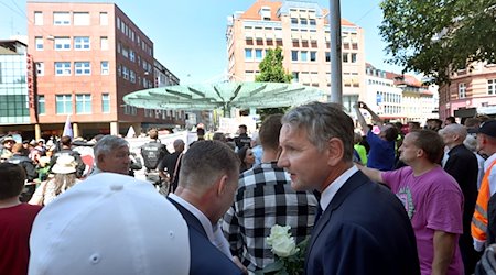 Björn Höcke steht am 25. Juni 2023 mit AfD-Sympathisanten vor Gegendemonstranten nahe einer Gedenkstele. / Foto: Karl-Josef Hildenbrand/dpa