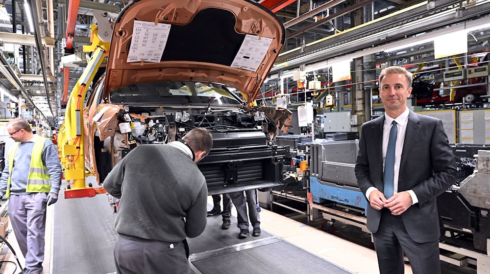 Florian Huettl, Geschäftsführer der Opel Automobile GmbH, steht neben einem Opel Grandland electric. / Foto: Martin Schutt/dpa