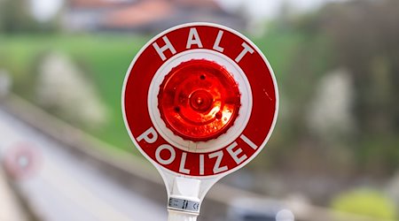 Eine Kelle mit der Aufschrift „Halt Polizei“ wird während einer Verkehrskontrolle hochgehalten. / Foto: Armin Weigel/dpa