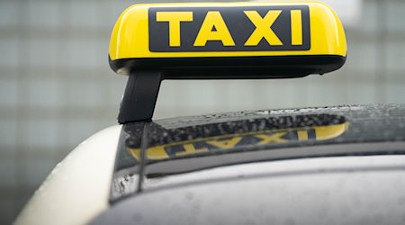 Ein Taxi-Schild ist auf dem Dach eines Fahrzeuges befestigt. / Foto: Frank Rumpenhorst/dpa