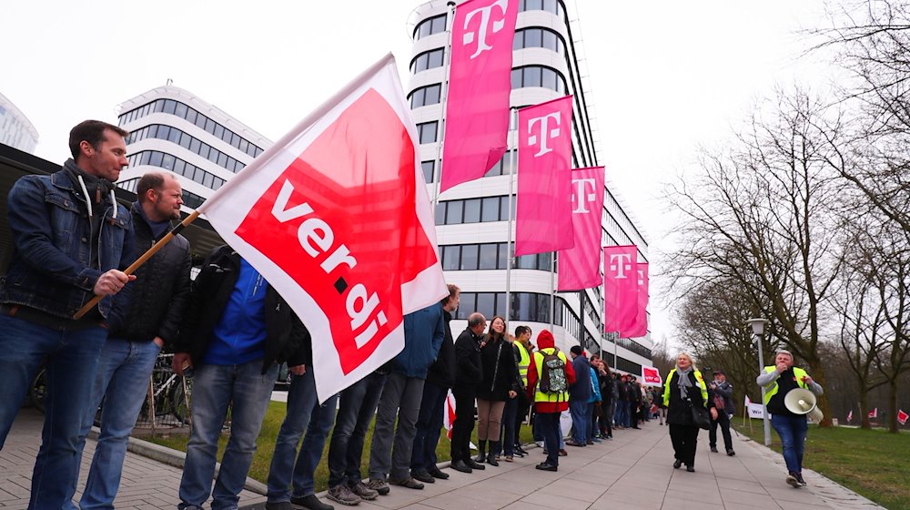 Telekom-Beschäftigte bilden bei einer Demonstration der Dienstleistungsgewerkschaft Verdi eine Menschenkette vor dem neuen Konzernhaus. / Foto: Christian Charisius/dpa/Archivbild