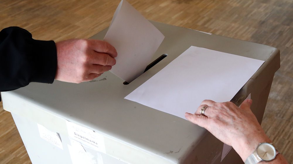 Eine Wählerin wirft ihren Wahlschein in einem Thüringer Wahllokal in die Wahlurne. / Foto: Bodo Schackow/dpa-Zentralbild/dpa/Archivbild