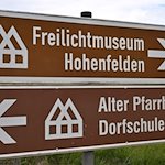 Ein Schild zeigt den Weg zum Thüringer Freilichtmuseum Hohenfelden. / Foto: Martin Schutt/dpa