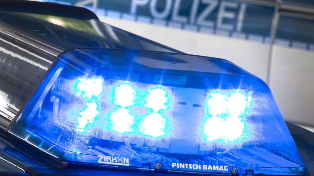 Eine Blaulicht leuchtet auf dem Dach eines Polizeiwagens. Im Hintergrund steht ein weiterer Streifenwagen. / Foto: Friso Gentsch/dpa