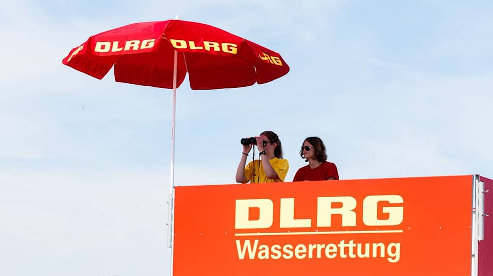 Zwei DLRG-Rettungsschwimmerinnen beobachten von ihrem Hochsitz aus das Treiben am Südstrand von Damp. / Foto: Markus Scholz/dpa/Archivbild