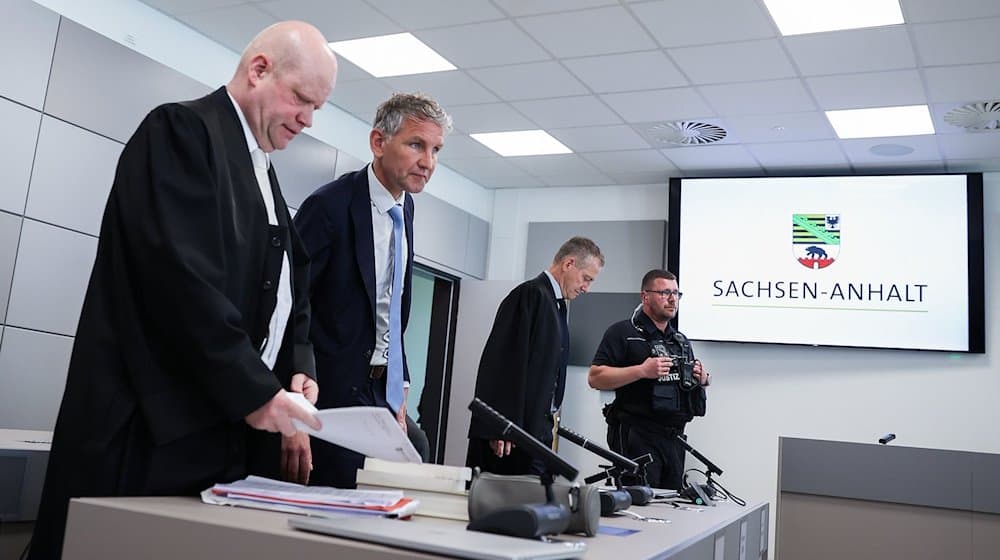Björn Höcke (2.v.l.), Vorsitzender der Thüringer AfD, steht neben seinen Anwälten Ulrich Vosgerau (l) und Ralf Hornemann (2.v.r.) zu Beginn seines Prozesses im Landgericht. / Foto: Ronny Hartmann/AFP Pool/dpa