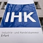 «IHK» steht auf dem Schild vor dem Haus der Industrie- und Handelskammer Erfurt. / Foto: Martin Schutt/dpa