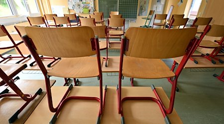 Stühle stehen in einem Klassenzimmer auf den Tischen. / Foto: Martin Schutt/dpa/Symbolbild