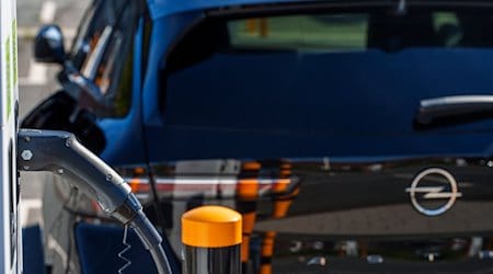 Ein Elektro-Fahrzeug der Marke Opel steht auf dem Mitarbeiterparkplatz an einer Ladestation. / Foto: Andreas Arnold/dpa