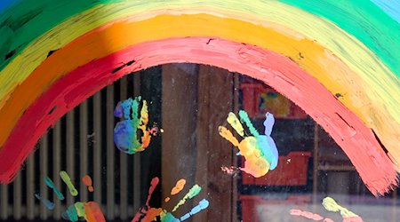 Kinderhände und ein Regenbogen sind an einer Kita zu sehen. / Foto: Jens Kalaene/dpa-Zentralbild/dpa