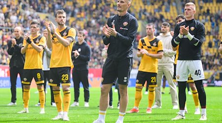 Dynamos Spieler um Kapitän Stefan Kutschke stehen nach dem Spiel vor den Fans. / Foto: Robert Michael/dpa