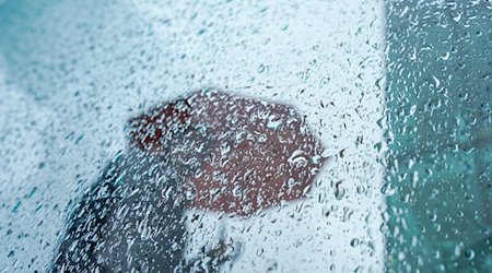 Ein Passant mit Regenschirm. / Foto: Marcus Brandt/dpa/Symbolbild