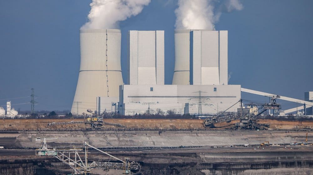 Schaufelradbagger und ein Absetzer arbeiten im Tagebau Vereinigtes Schleenhain vor der Kulisse des Kraftwerks Lippendorf. / Foto: Jan Woitas/dpa