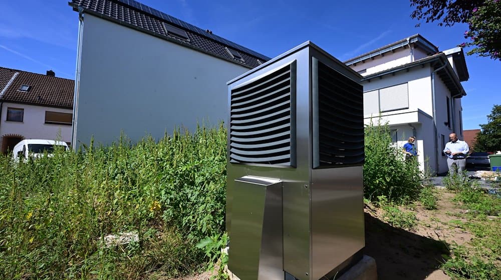 Vor einem neu gebauten Wohngebäude ist im Garten eine Wärmepumpe zum Heizen des Gebäudes in Betrieb. / Foto: Bernd Weißbrod/dpa