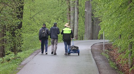 Spaziergänger laufen auf einem Weg im Thüringer Mühltal. / Foto: Bodo Schackow/dpa-Zentralbild/dpa