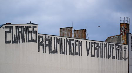 Auf der Brandmauer eines Wohnhauses ist der Schriftzug «Zwangsräumungen verhindern» zu sehen. / Foto: Monika Skolimowska/dpa/Archivbild