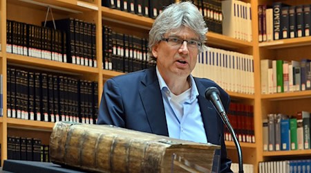 Reinhard Laube, Direktor der Herzogin Anna Amalia Bibliothek, spricht über eine restaurierte 270 Jahre alte Bibel aus dem Ahrtal. / Foto: Martin Schutt/dpa