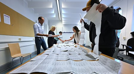 Wahlhelfer sortieren die Stimmzettel der Stichwahl und der Europawahl in einem Wahllokal in Erfurt. / Foto: Martin Schutt/dpa