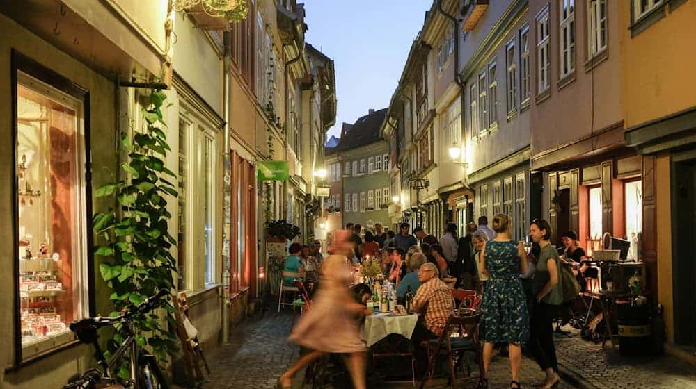 Menschen feiern auf der Krämerbrücke am Abend. / Foto: Jens Kalaene/dpa-Zentralbild/dpa/Archivbild