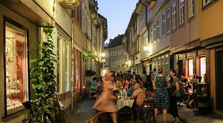 Menschen feiern auf der Krämerbrücke am Abend. / Foto: Jens Kalaene/dpa-Zentralbild/dpa/Archivbild