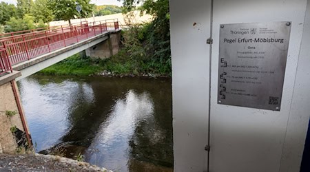 Ein Schild am Pegel Erfurt-Möbisburg zeigt historische Wasserstände der Gera. / Foto: Michael Reichel/dpa