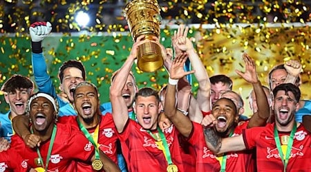 Leipzigs Willi Orban hält die Siegertrophäe in die Höhe und bejubelt mit seinen Teamgefährten den Pokalsieg. Nun nimmt RB Anlauf zum dritten Titelgewinn im DFB-Pokal. / Foto: Tom Weller/dpa