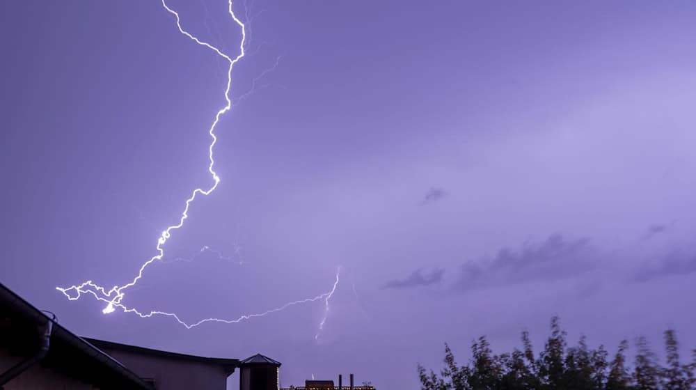 Ein Blitz entlädt sich über einem Wohngebiet in Magdeburg Stadtfeld. / Foto: Stephan Schulz/dpa/Archivbild