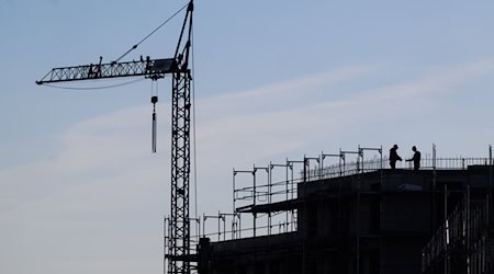 Bauarbeiter stehen auf der Baustelle eines Mehrfamilienhauses. / Foto: Julian Stratenschulte/dpa/Symbolbild