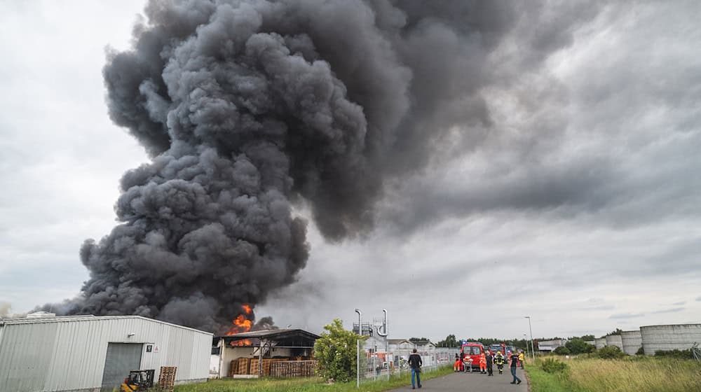 Schwarzer Rauch steigt beim Brand einer Lagerhalle in den Himmel. Bei dem Brand in einer Lagerhalle im Saale-Orla-Kreis ist am Donnerstagmittag ein Sachschaden in Höhe von etwa 600 000 bis 800 000 Euro entstanden. Wie eine Sprecherin der Polizei mitteilte, bildete sich durch das Feuer in Weira eine große schwarze Rauchwolke. / Foto: David Breidert/Tnn/dpa